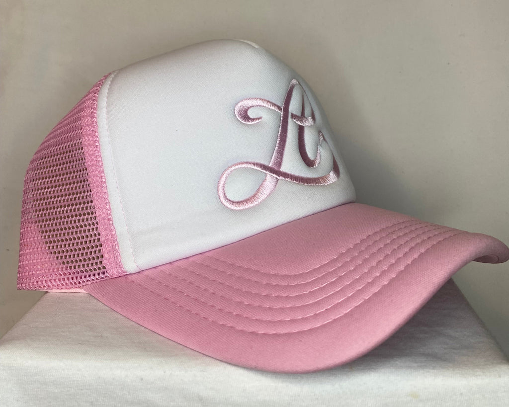 Pink and white cap with decorative design on a neutral background