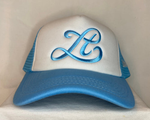 Blue and white cap with decorative emblem on a beige background